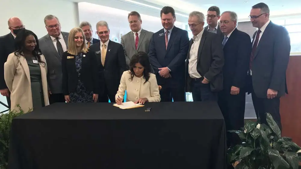 Group of people watching woman sign papers